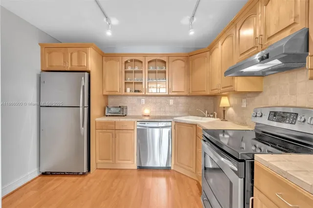 a kitchen with stainless steel appliances granite countertop a refrigerator and a sink