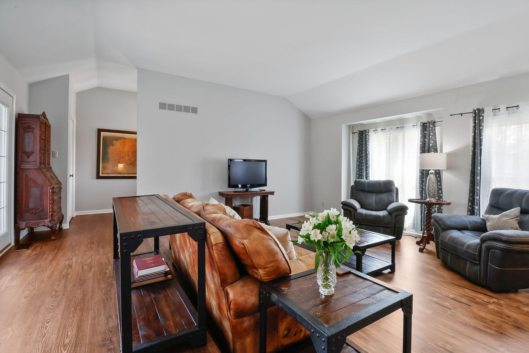 12819 Grant Street Crown Point, IN 46307 - Photo 4 of 42 a living room with furniture a wooden floor and a flat screen tv