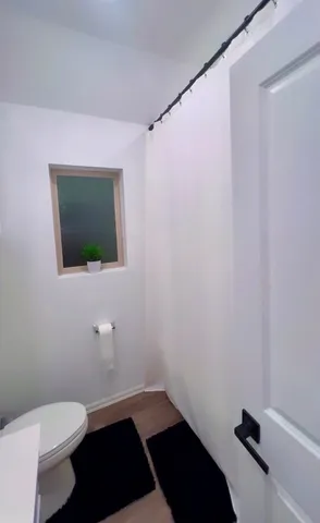 a bathroom with a toilet a sink and mirror