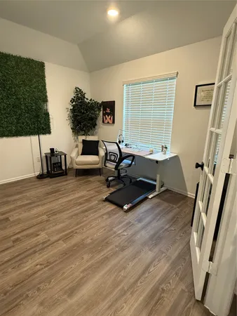 a living room with furniture hard wood floor and a large window