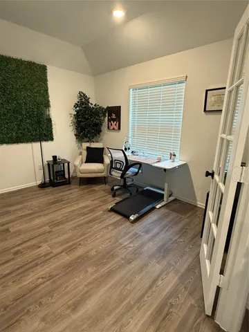 a living room with furniture hard wood floor and a large window