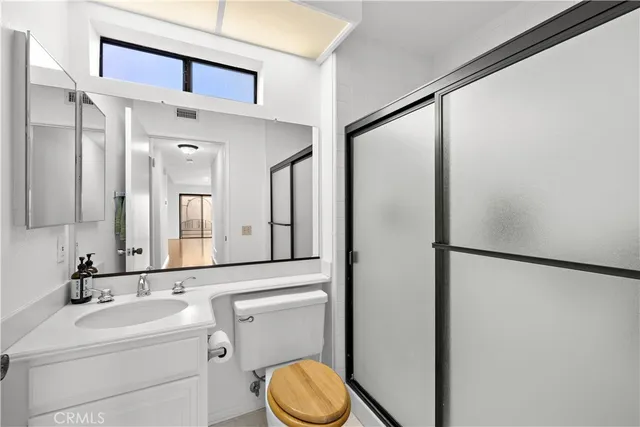 a bathroom with a toilet sink shower and mirror