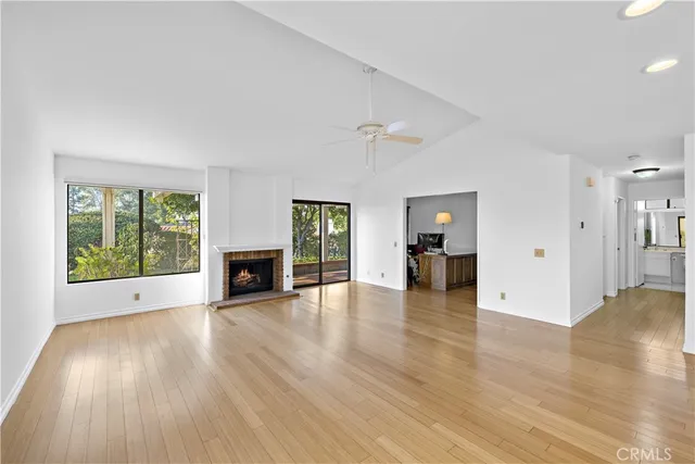 a view of a livingroom with wooden floor and a fireplace