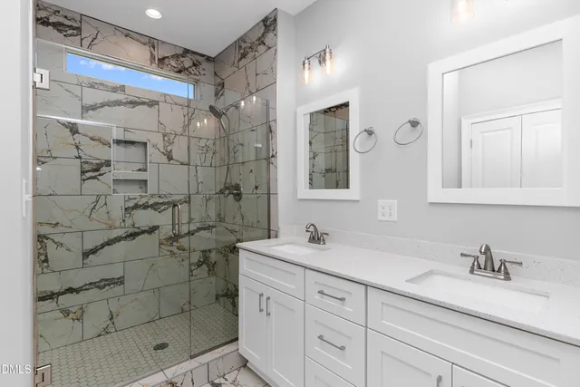 a bathroom with a shower sink and mirror