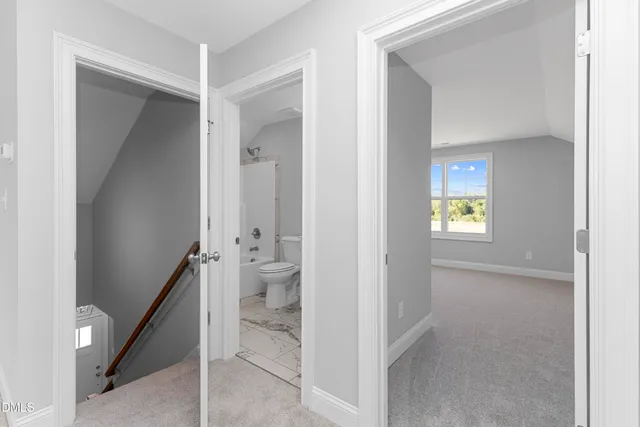 a view of an entryway with wooden floor and a bathroom
