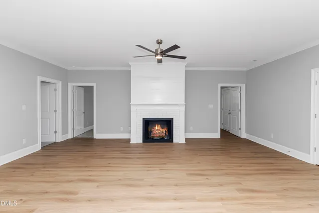 a view of a livingroom with a fireplace and a ceiling fan