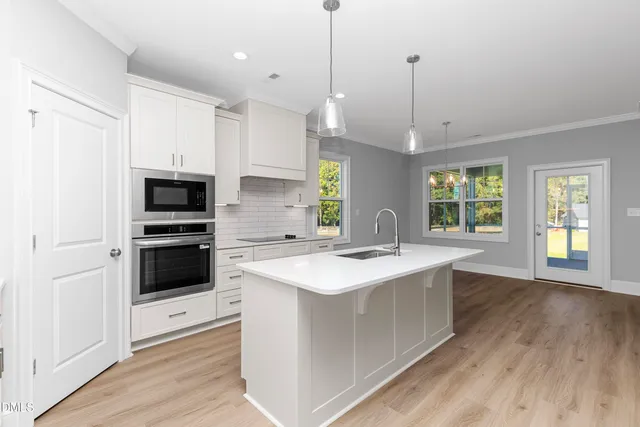 a kitchen with a sink a stove a microwave and a refrigerator