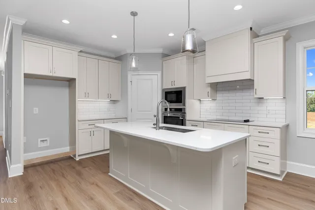 a kitchen with kitchen island a white counter top space cabinets and stainless steel appliances