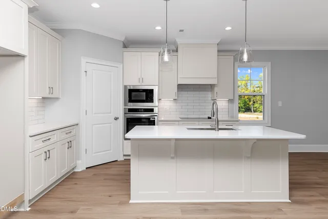 a kitchen with kitchen island white cabinets appliances and sink