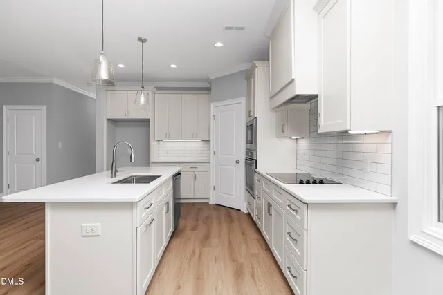 a kitchen with kitchen island a sink appliances and cabinets
