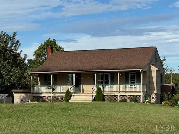a front view of a house with a garden and trees
