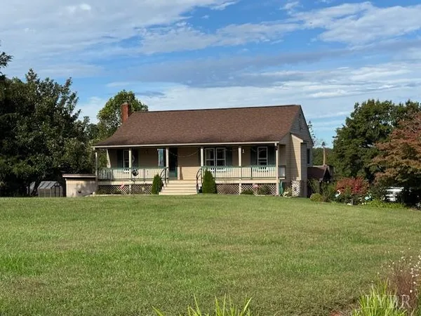 a front view of a house with a garden and sitting area