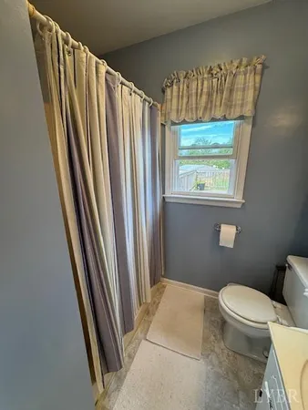 a bathroom with a granite countertop sink toilet and a large mirror