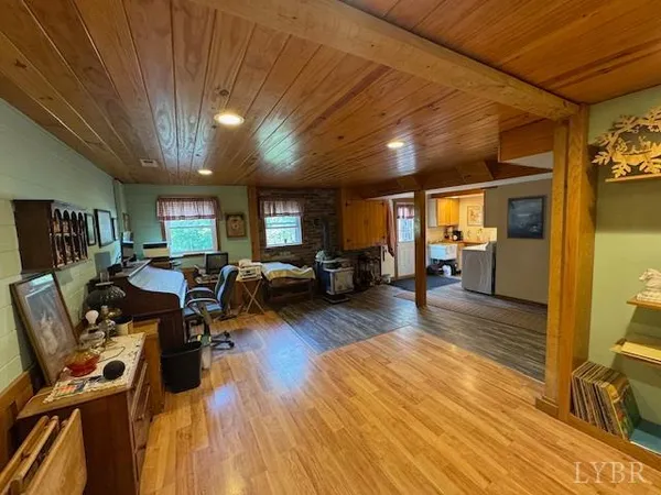 a living room with lots of furniture wooden floor and a large window