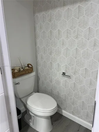 a white toilet sitting next to a shower