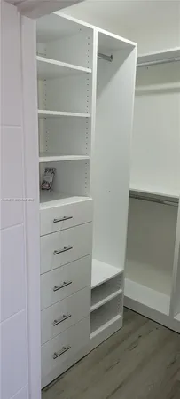 a view of walk in closet with empty racks