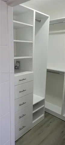 a view of walk in closet with empty racks