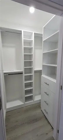 a view of walk in closet with empty racks