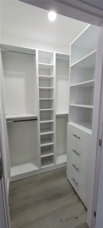 a view of walk in closet with empty racks