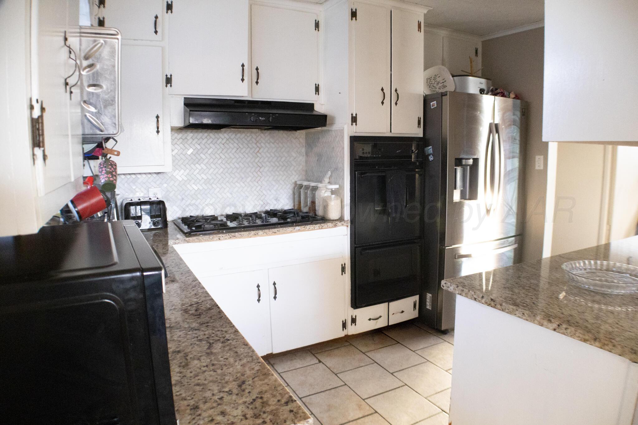 4711 South Rusk Street Amarillo, TX 79110 - Photo 11 of 24 a kitchen with a refrigerator and a stove