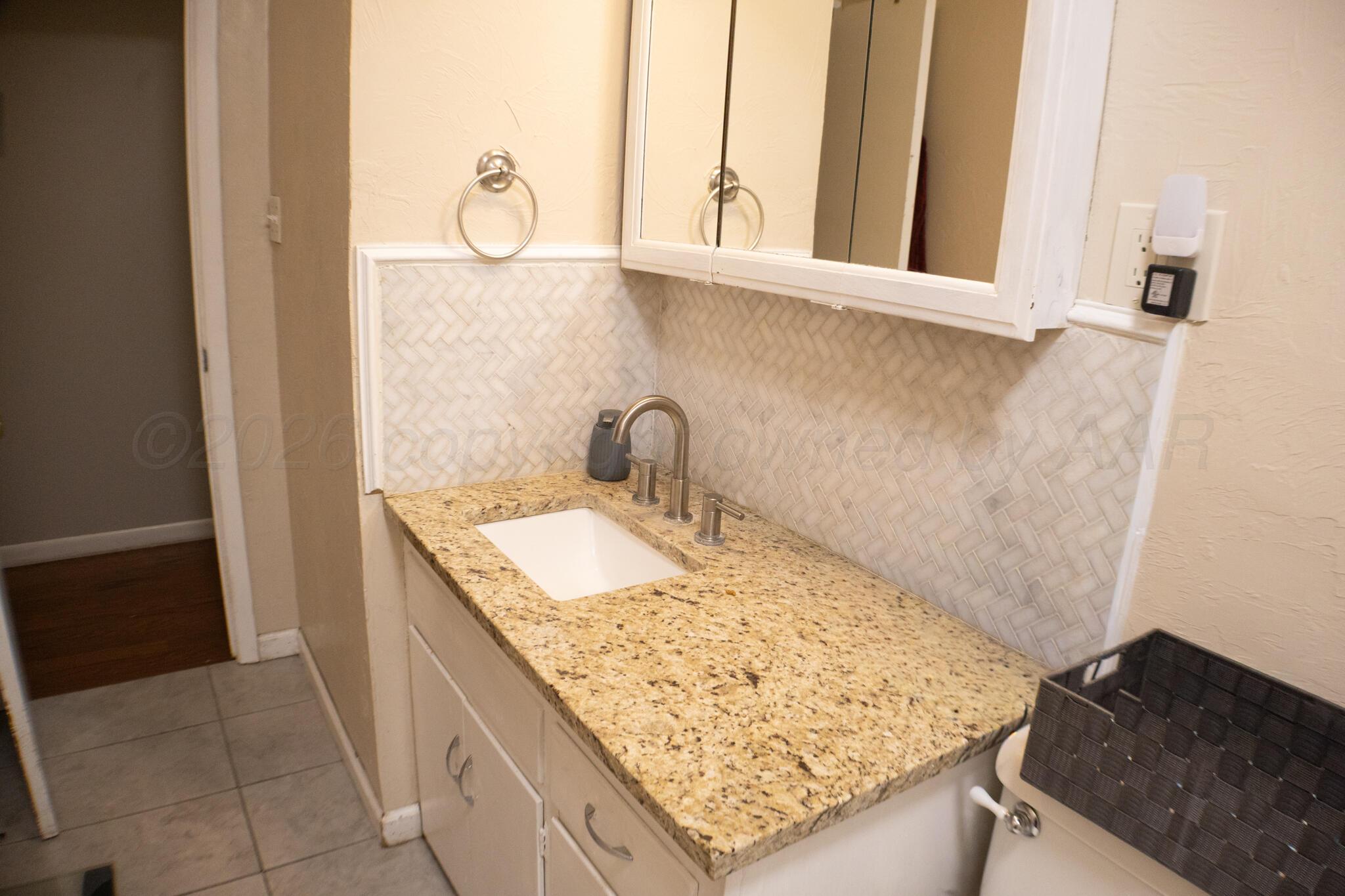 4711 South Rusk Street Amarillo, TX 79110 - Photo 14 of 24 a bathroom with a granite countertop sink and a mirror