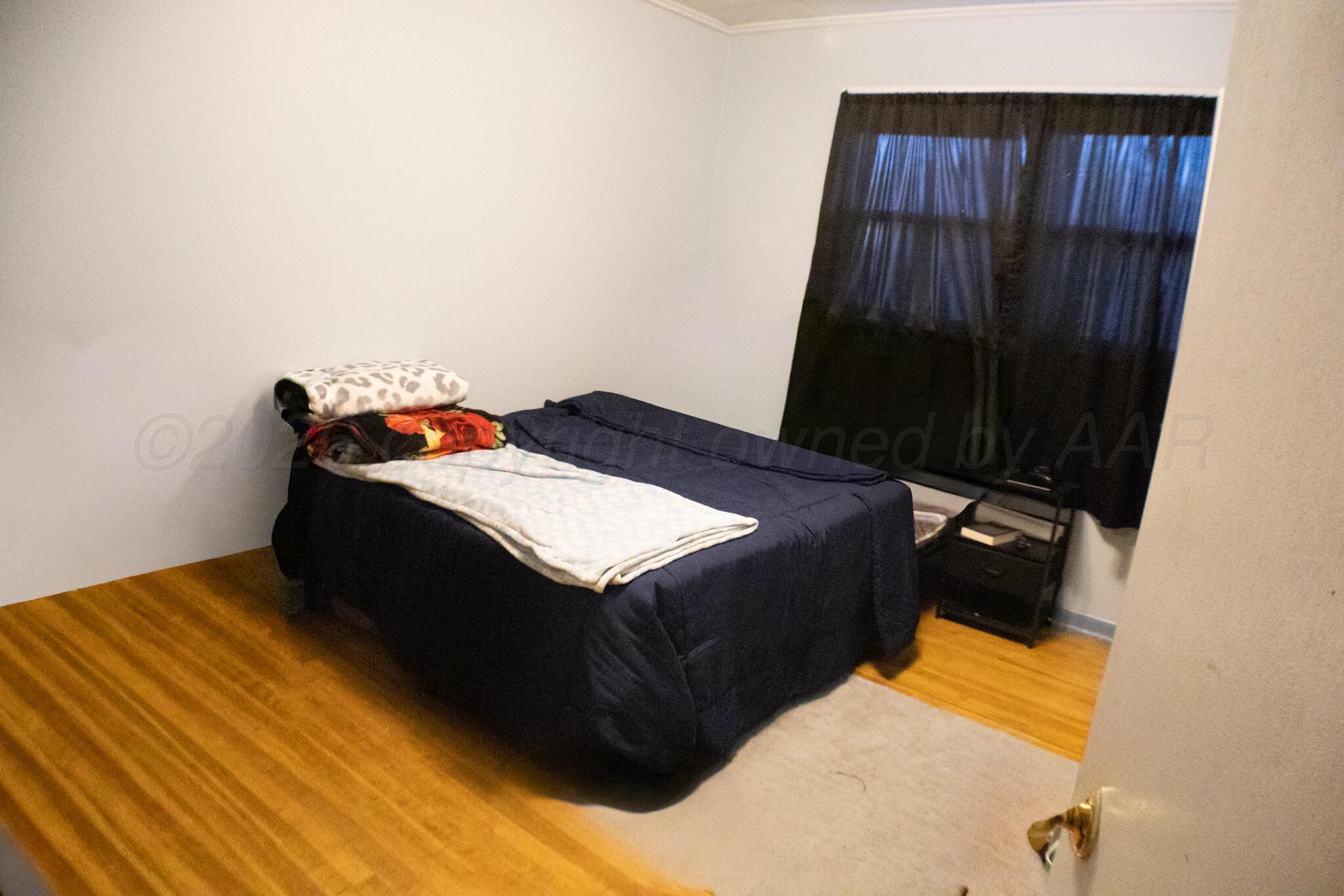 4711 South Rusk Street Amarillo, TX 79110 - Photo 15 of 24 a bed sitting in a bedroom next to a window
