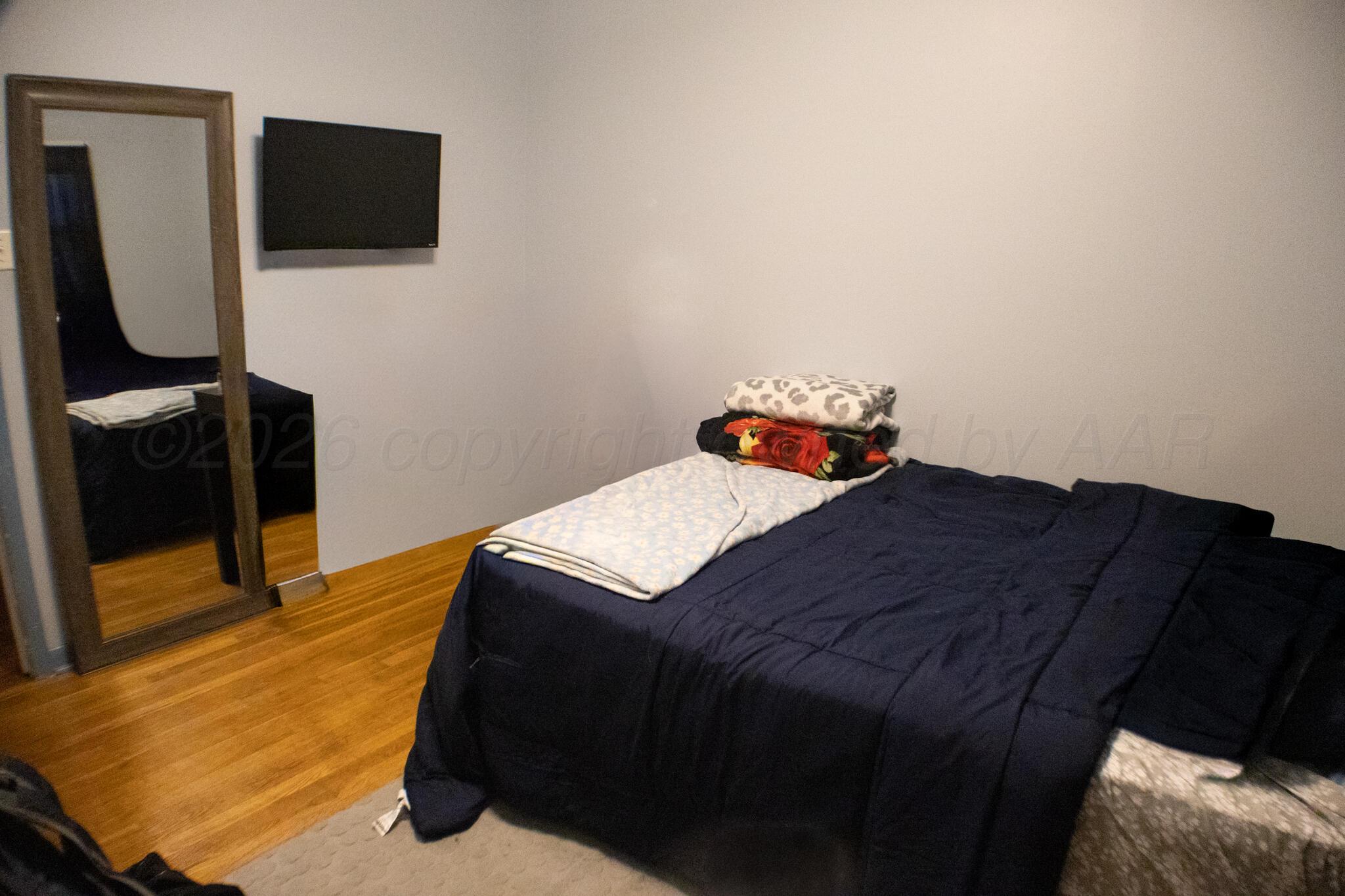 4711 South Rusk Street Amarillo, TX 79110 - Photo 16 of 24 a bedroom with a bed and flat screen tv