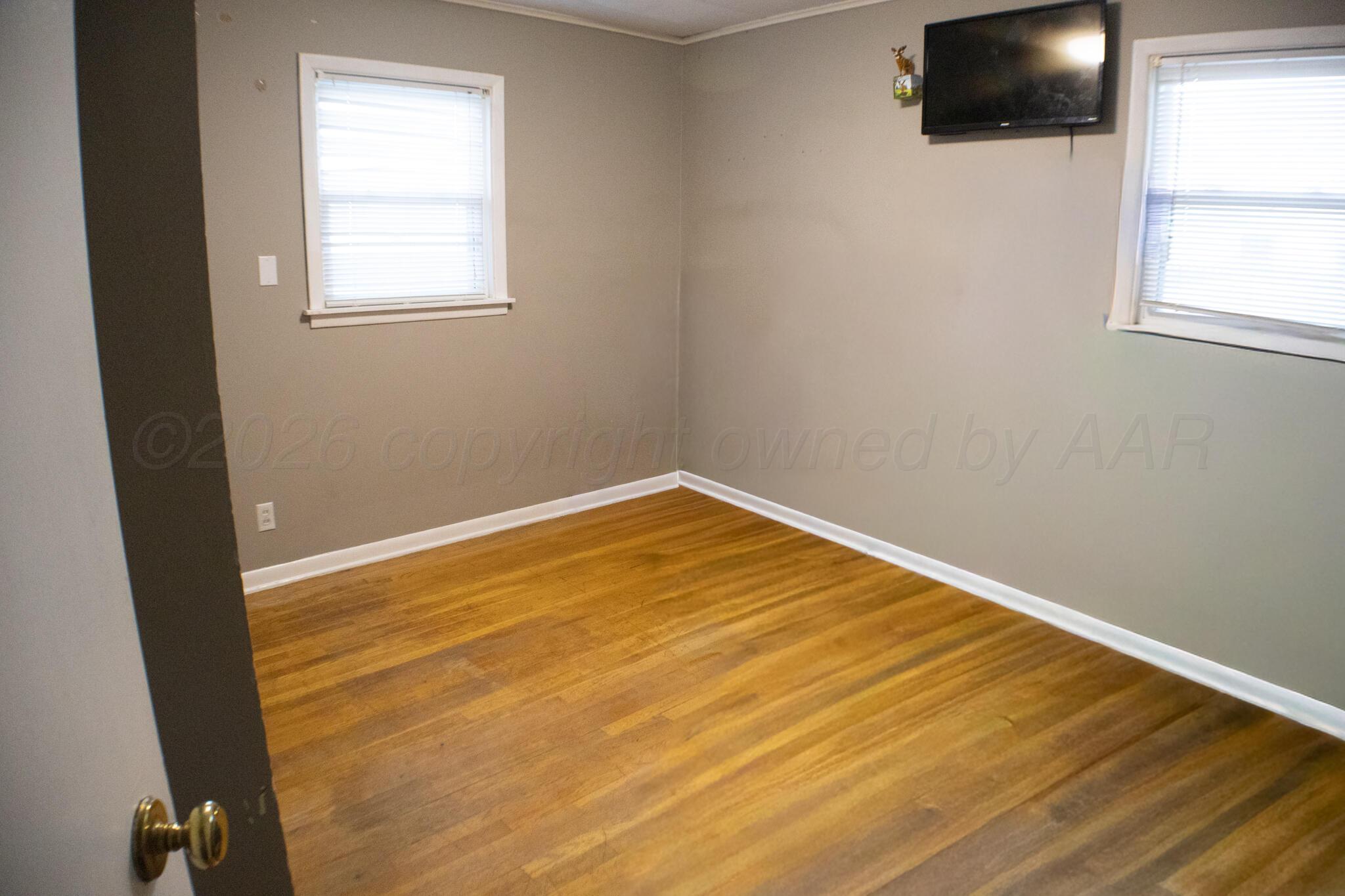 4711 South Rusk Street Amarillo, TX 79110 - Photo 18 of 24 an empty room with wooden floor and windows