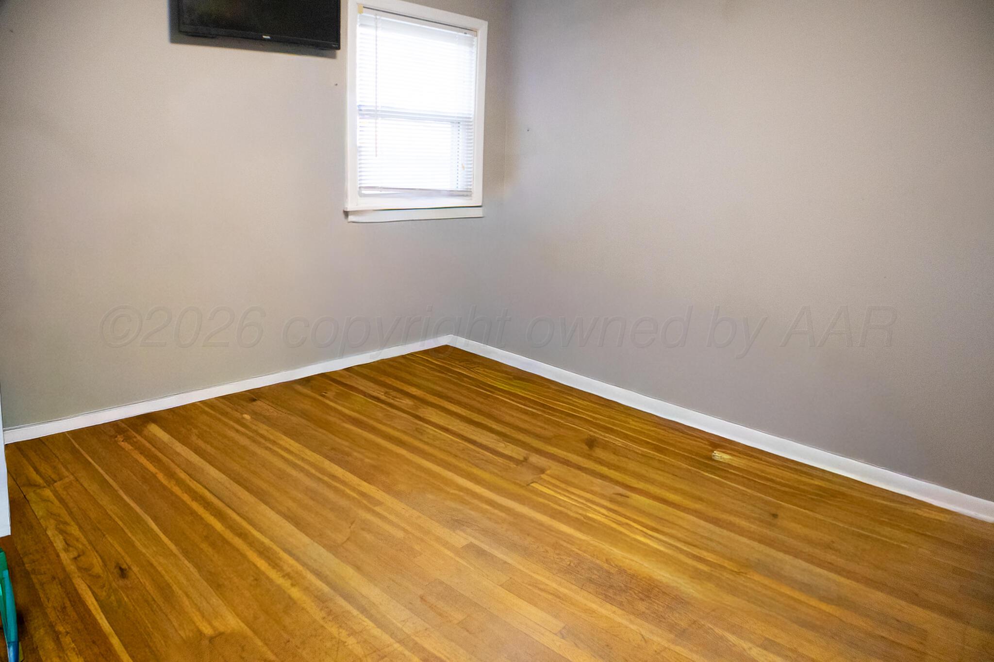 4711 South Rusk Street Amarillo, TX 79110 - Photo 19 of 24 a view of a room with wooden floor and white walls