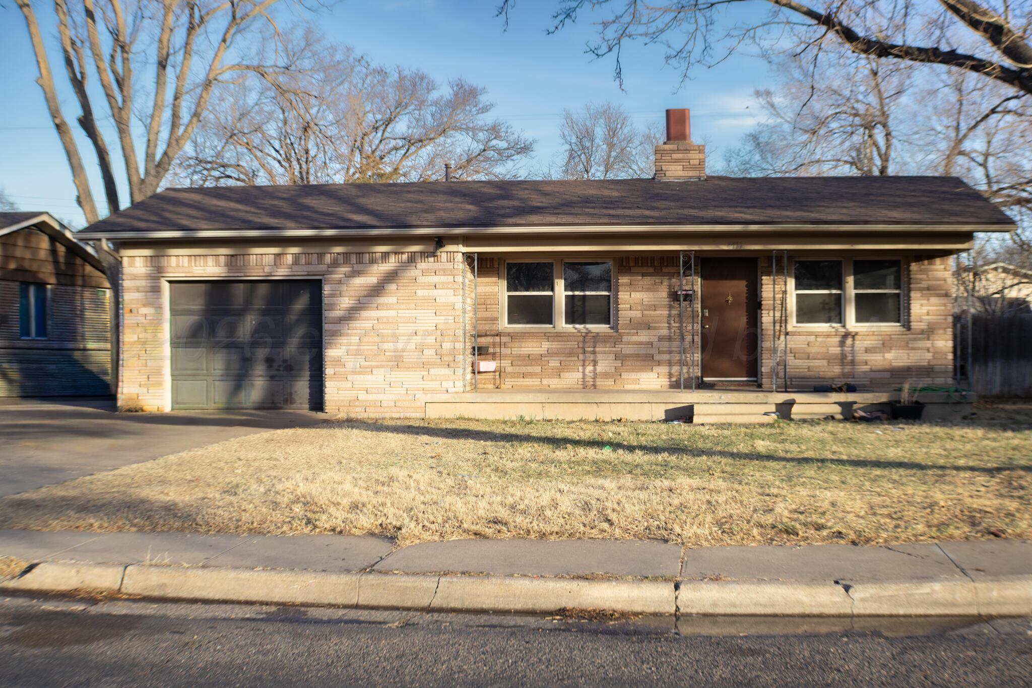 4711 South Rusk Street Amarillo, TX 79110 - Photo 2 of 24 a front view of a house with a yard and garage