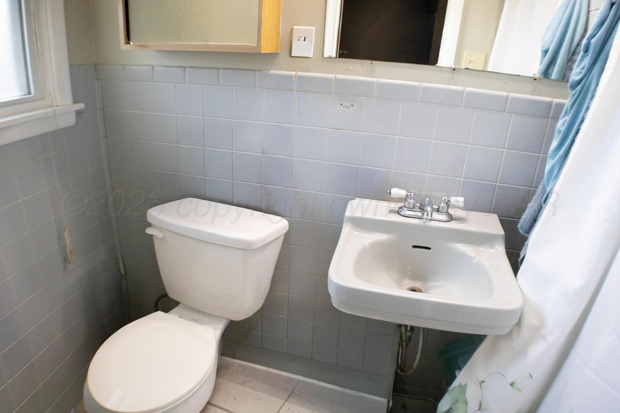 4711 South Rusk Street Amarillo, TX 79110 - Photo 22 of 24 a white toilet sitting next to a white sink