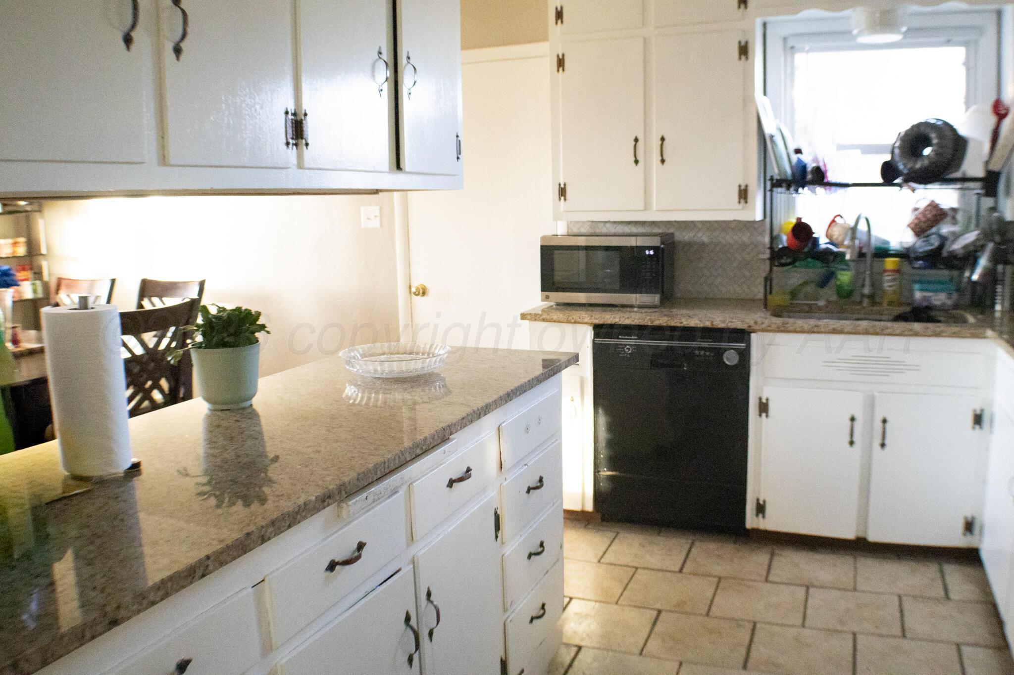 4711 South Rusk Street Amarillo, TX 79110 - Photo 10 of 24 a kitchen with stainless steel appliances granite countertop a sink and a stove