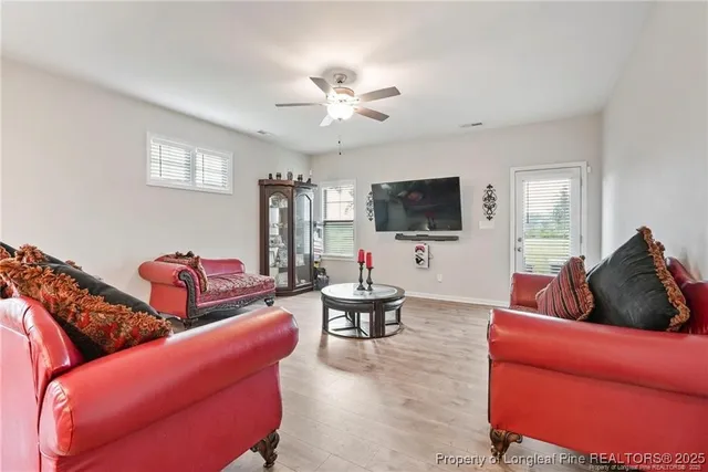 a living room with furniture kitchen view and a flat screen tv
