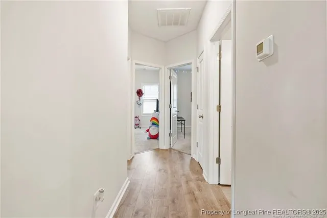 a view of hallway with wooden floor
