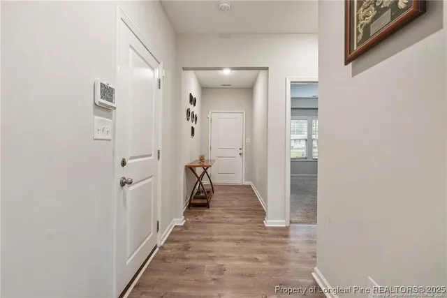 a view of a hallway with wooden floor and staircase