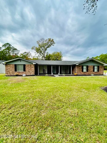 a front view of the house with yard and trees