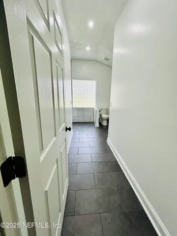 a bathroom with a granite countertop toilet sink and mirror