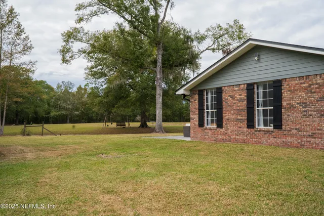 a view of a house with a yard and sitting area