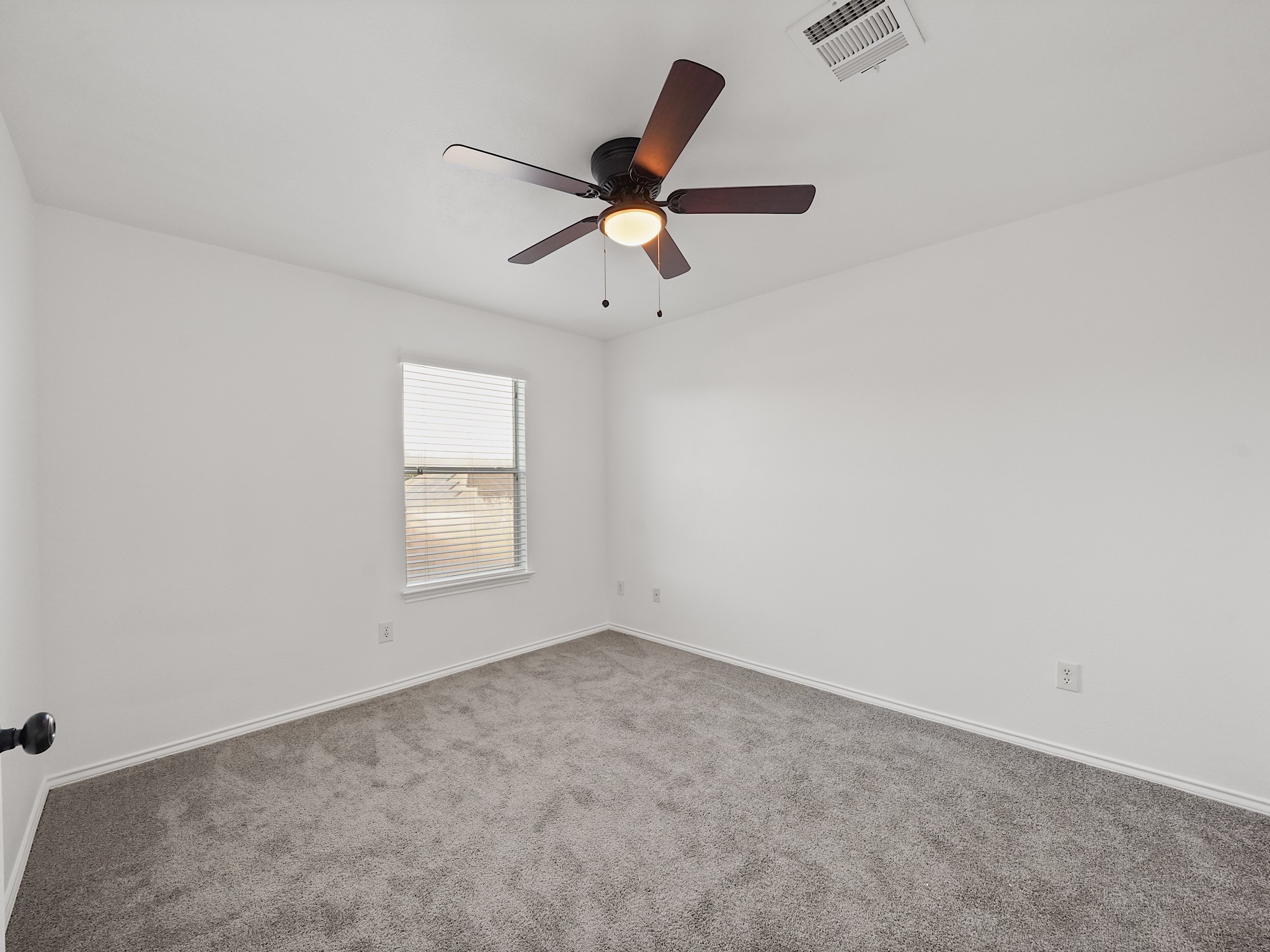 14206 Windy Ridge Lane Rosharon, TX 77583 - Photo 14 of 15 This is a bright, spacious room with neutral carpet and white walls, featuring a ceiling fan and a window allowing natural light.