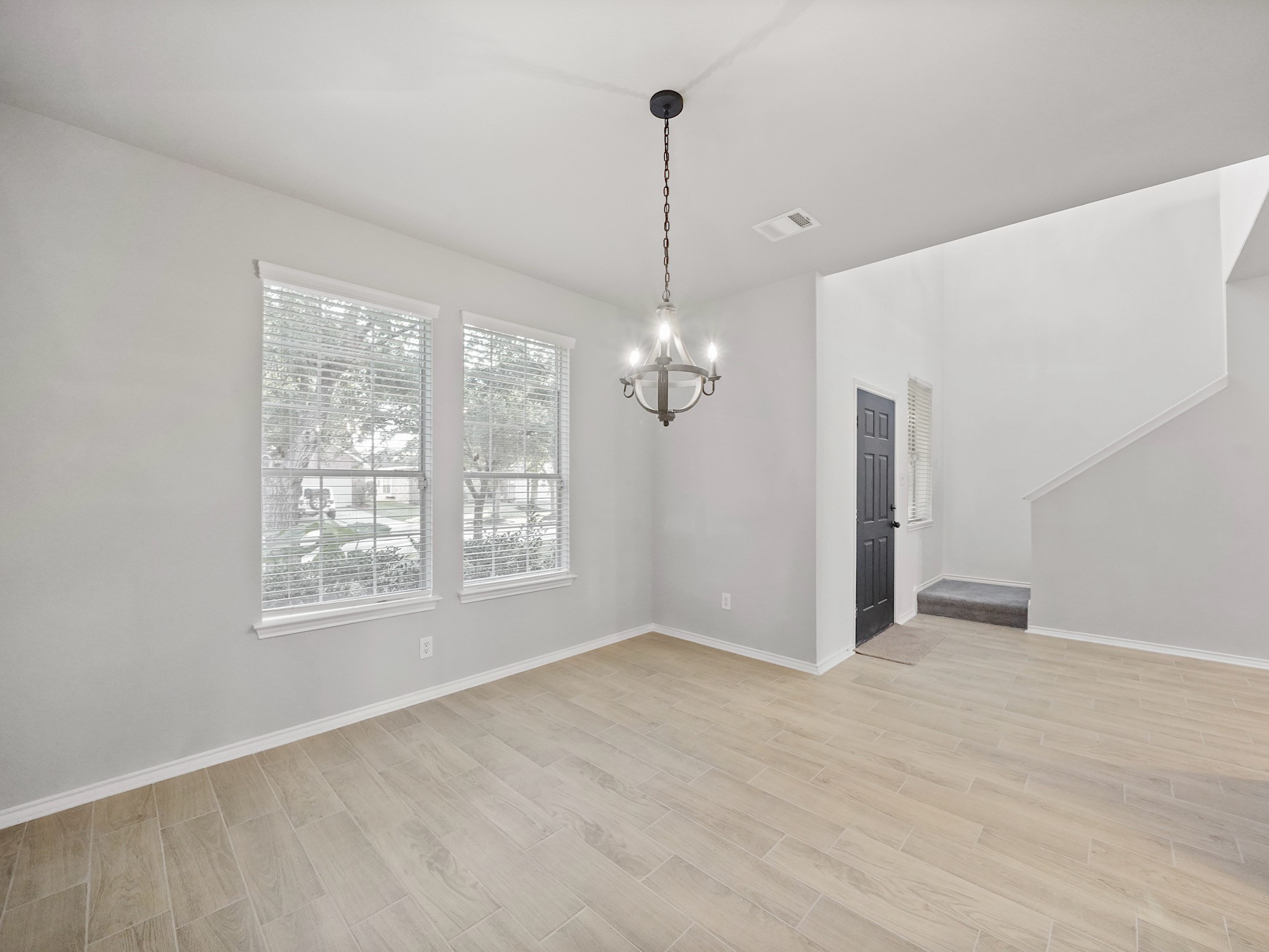 14206 Windy Ridge Lane Rosharon, TX 77583 - Photo 2 of 15 Elegant dining room featuring abundant natural light and a stylish chandelier, perfect for hosting memorable dinners.