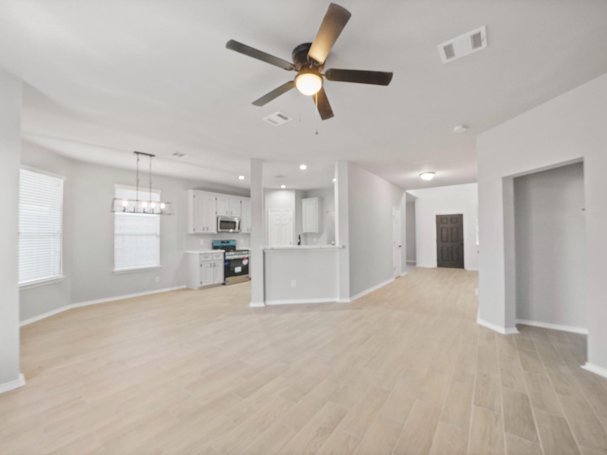 14206 Windy Ridge Lane Rosharon, TX 77583 - Photo 3 of 15 Experience seamless living with an open-concept family room and kitchen, complemented by stunning new floors throughout.