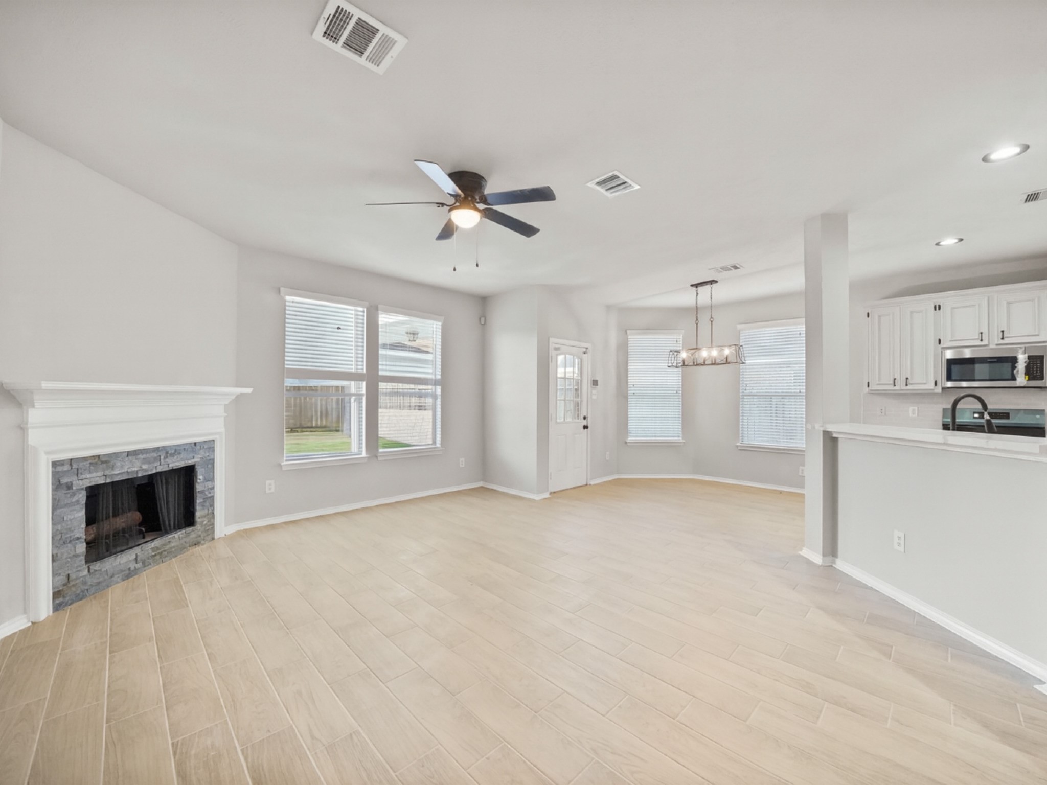 14206 Windy Ridge Lane Rosharon, TX 77583 - Photo 4 of 15 Spacious eat-in kitchen seamlessly flows into the family room, featuring an elegant fireplace.