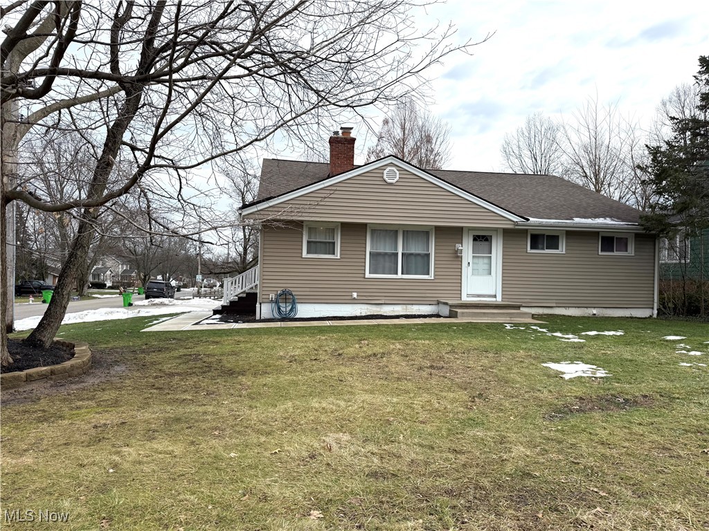 Rear view of property featuring a yard