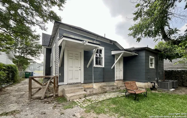 a backyard of a house with table and chairs