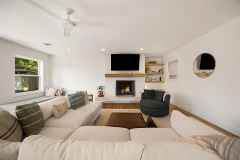 a living room with furniture a flat screen tv and a fireplace