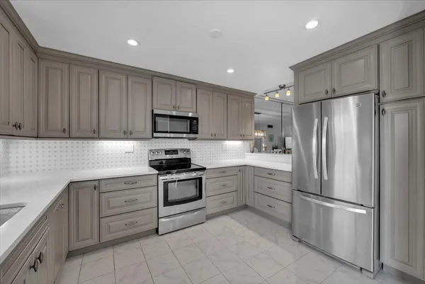a kitchen with stainless steel appliances granite countertop a refrigerator sink and cabinets