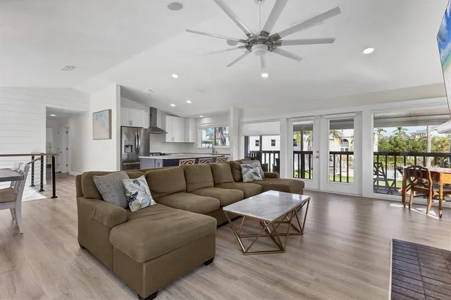 a living room with furniture and a large window with wooden floor