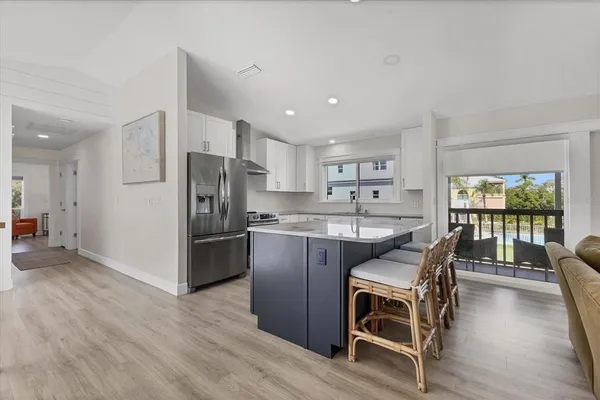a kitchen with stainless steel appliances granite countertop a refrigerator and wooden cabinets