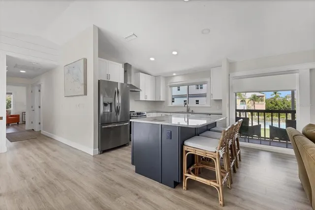 a kitchen with stainless steel appliances granite countertop a refrigerator and wooden cabinets