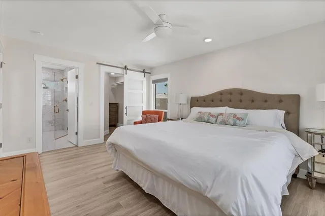 a spacious bedroom with a bed and a chandelier